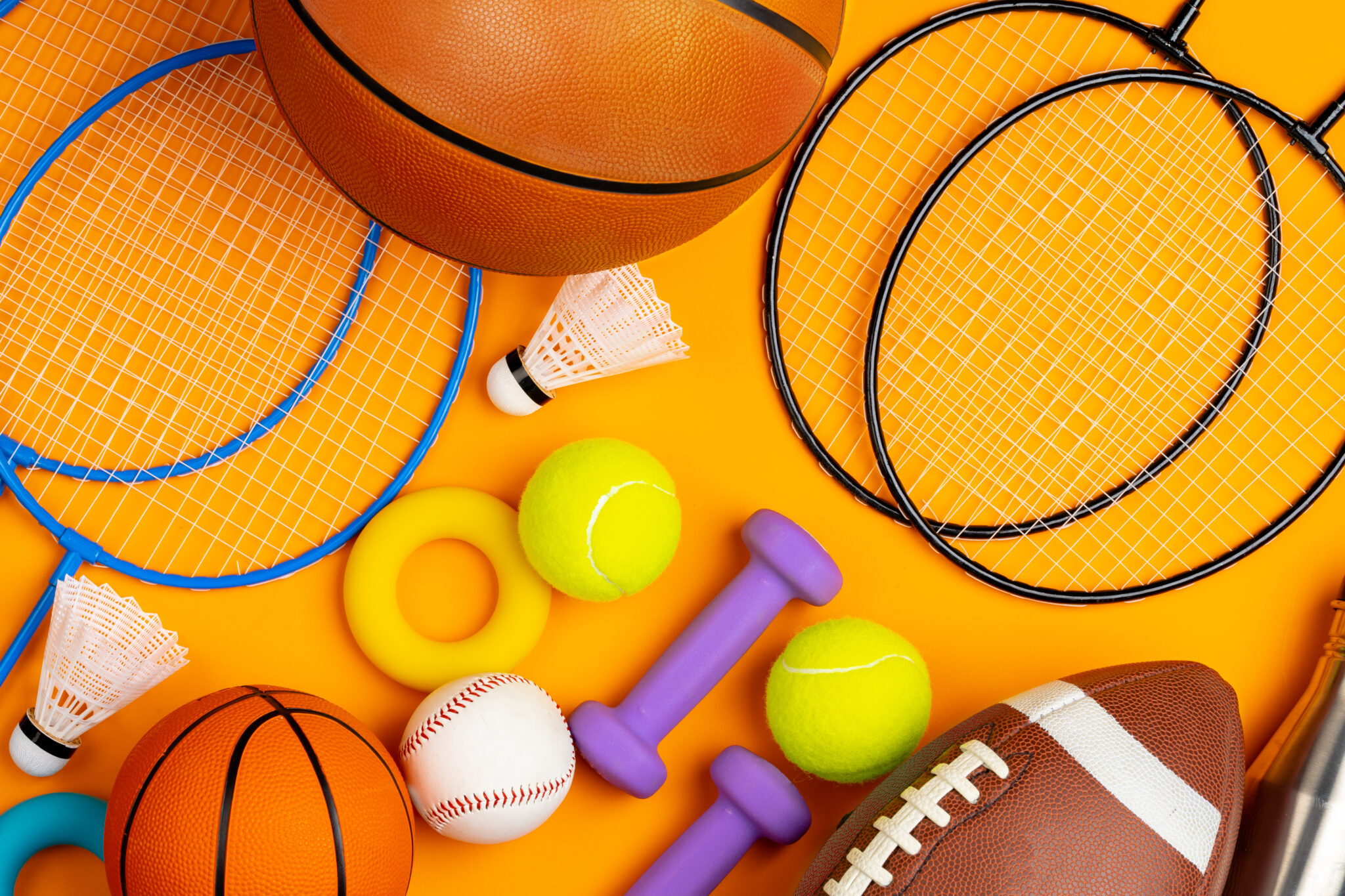 Assortment of sport equipment on yellow background, top view